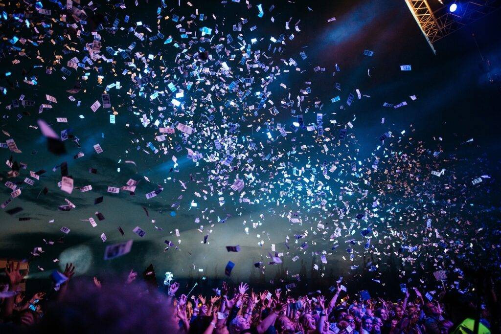 A music concert blasts confetti over an adoring crowd.