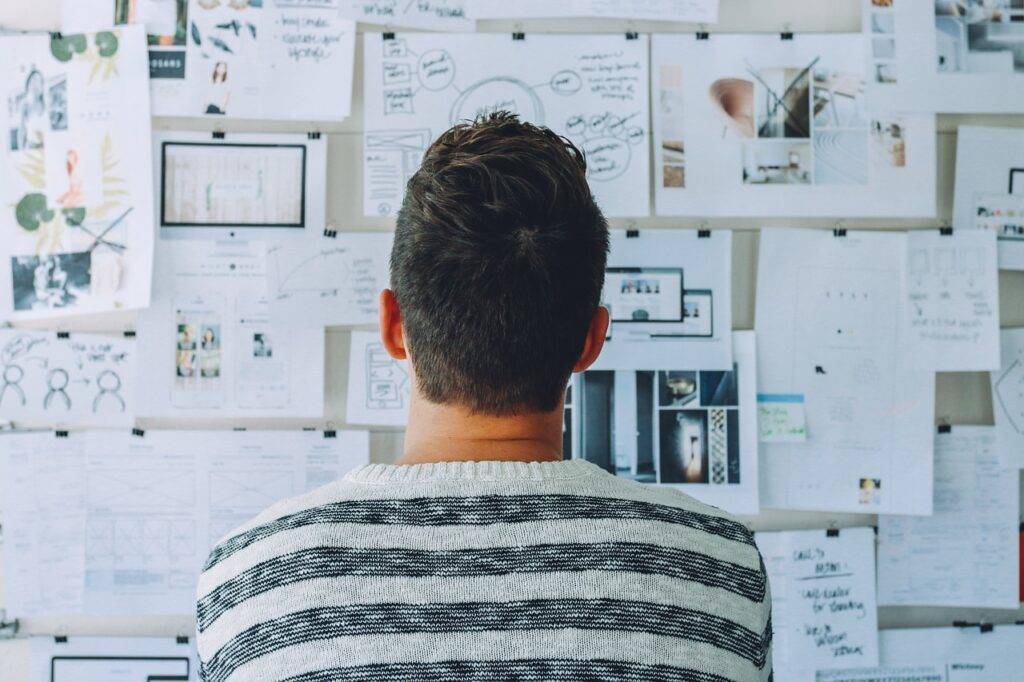 Man looking at an information board pondering thoughts and figuring out his dream.