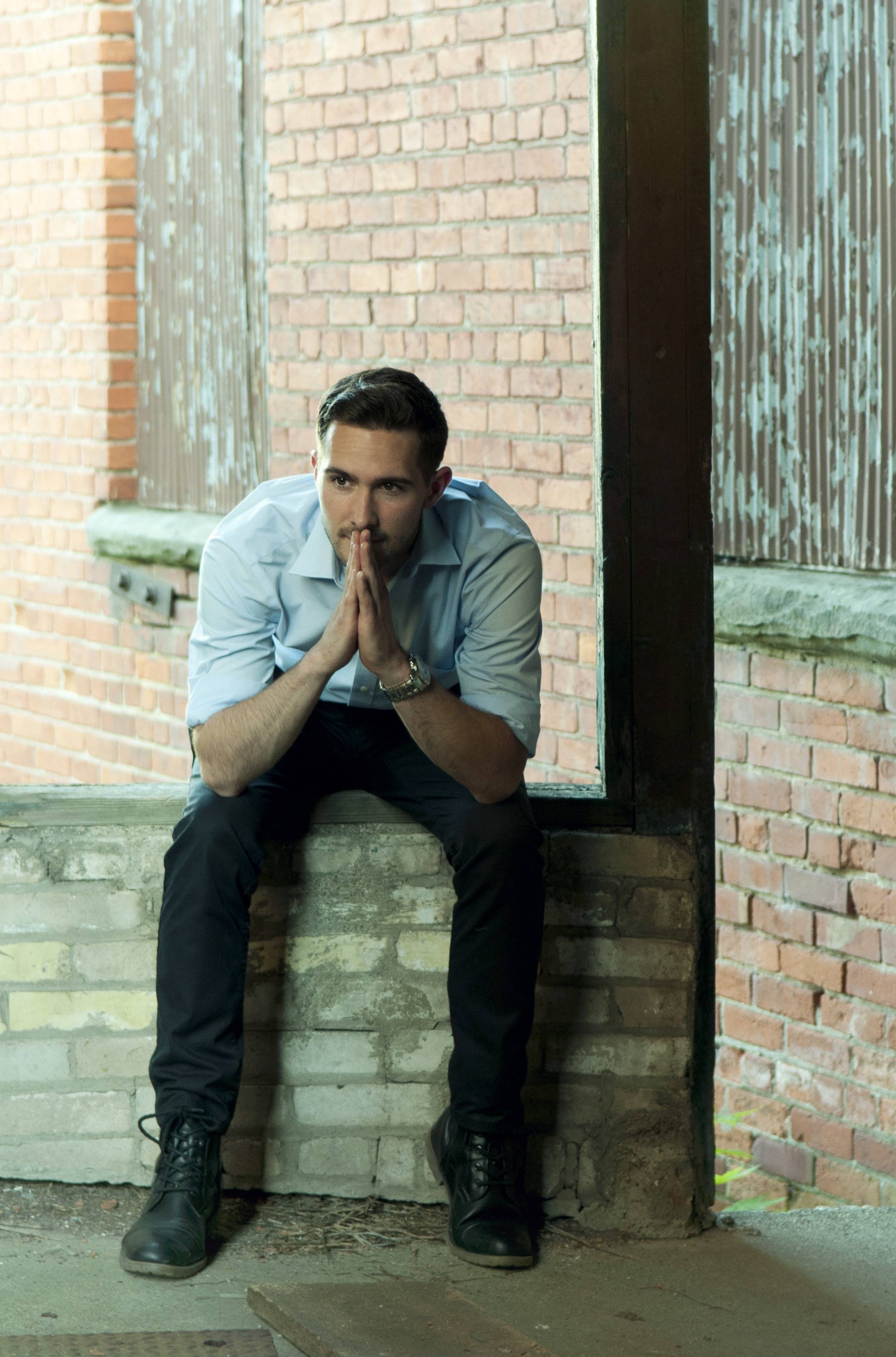 Tyler Jameson thinking deeply with a rustic background.