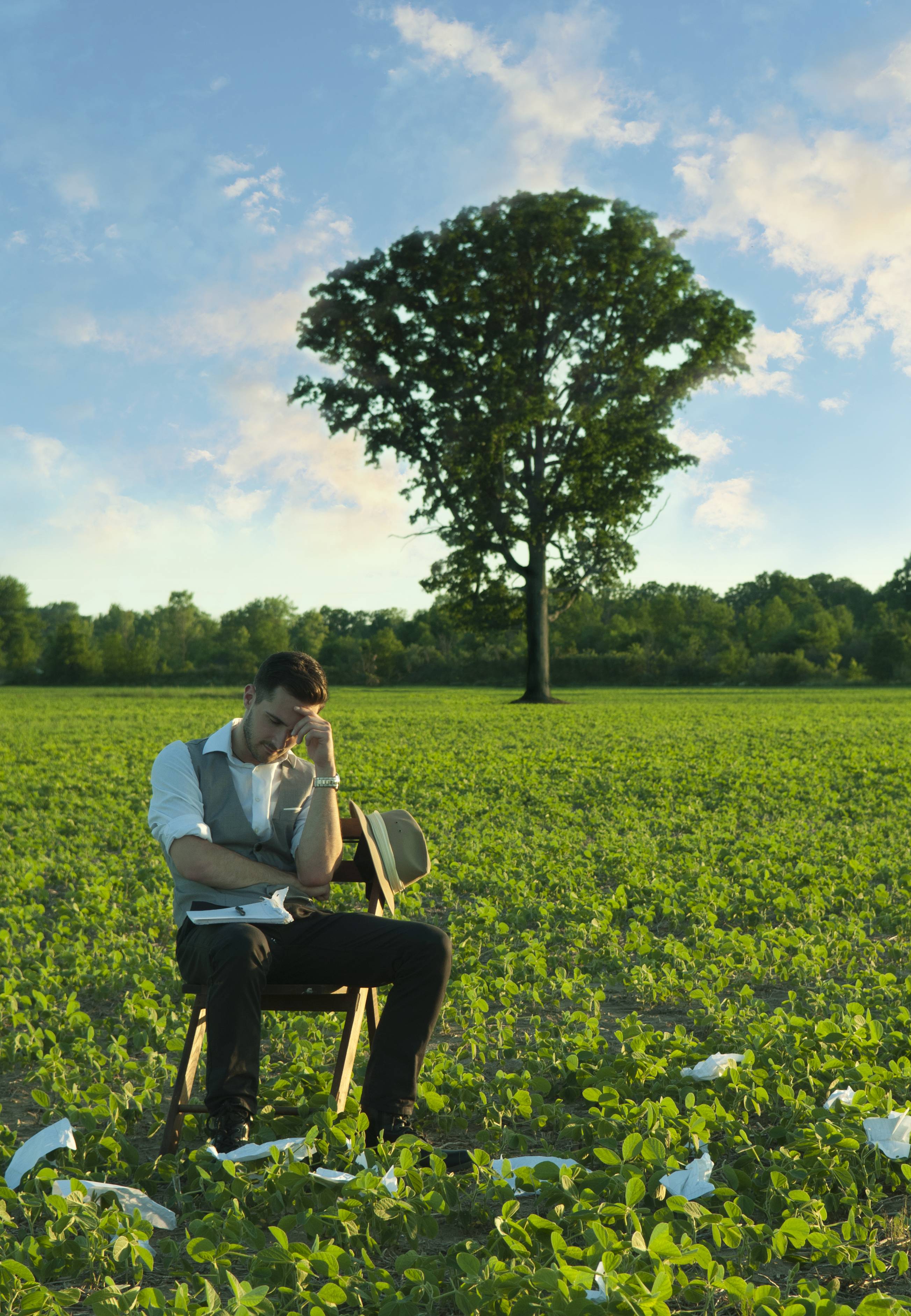 Tyler Jameson in a field with scattered pages.