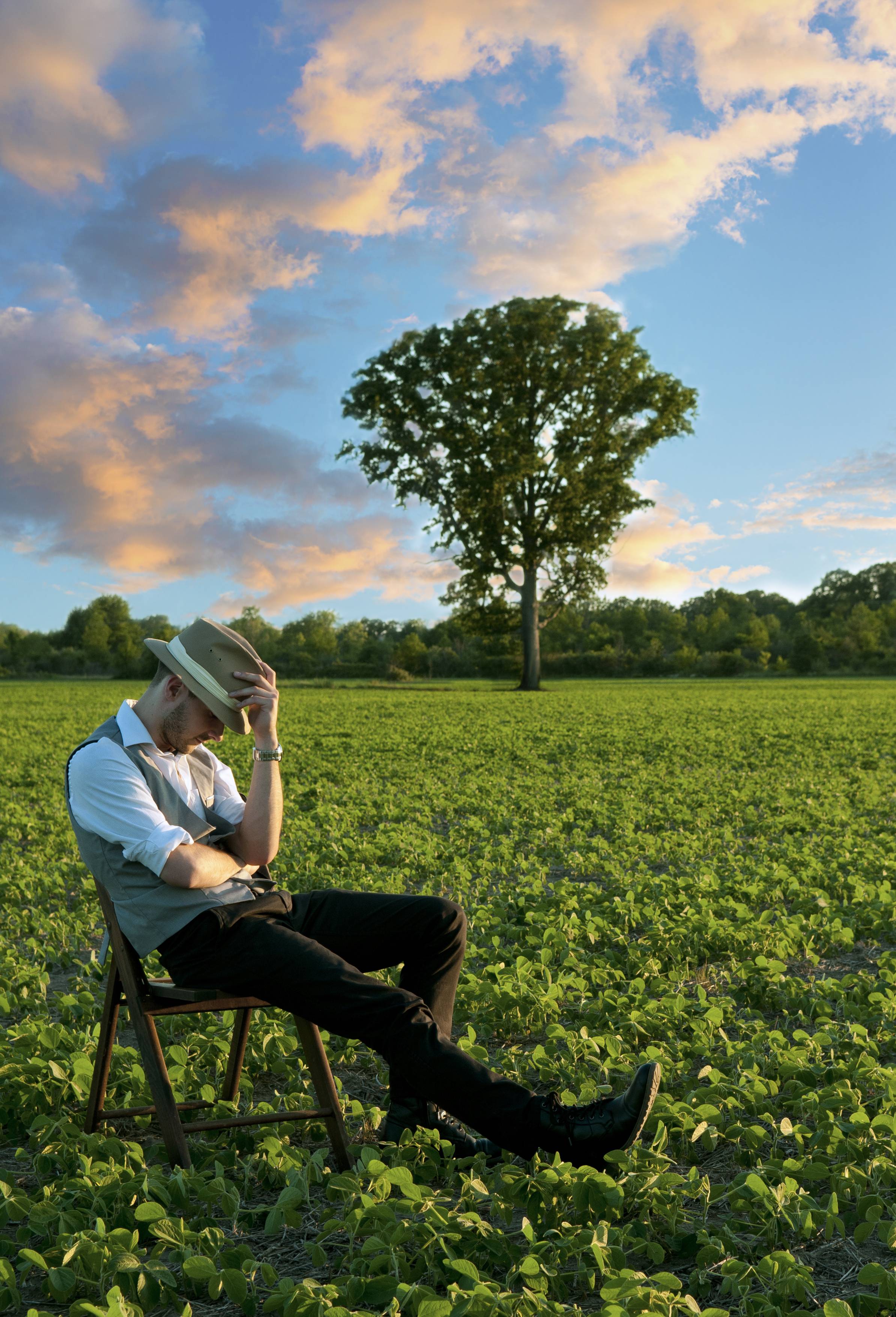 Tyler Jameson leaning back on a chair in a field.