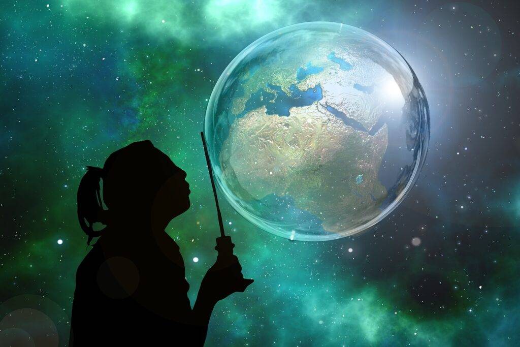 Girl blowing a bubble with the Earth contained inside of it showing the innocence of imagination.